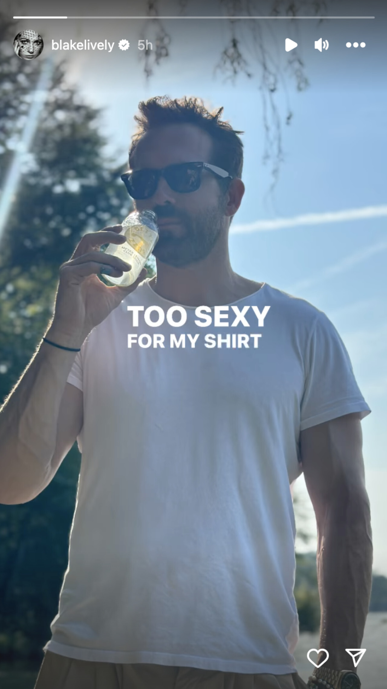 Ryan Reynolds trägt ein weißes T-Shirt und nippt an einem Getränk