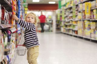 child in supermarket Toddler picking something from shelf in supermarket