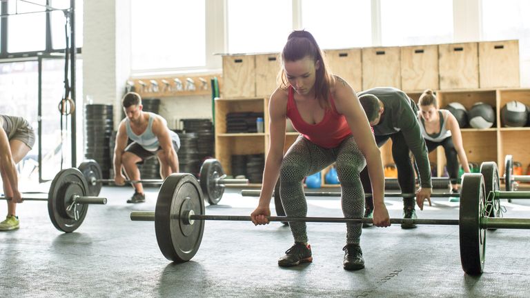 Woman doing deadlifts as part of a crossfit class