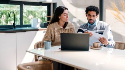 Stressed young couple going through their household finances using a laptop