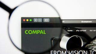 A magnifying glass focused on the Compal logo on the company's website