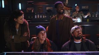 Linda Fiorentino looks disappointed as Jason Mewes Chris Rock and Kevin Smith are entertained in a strip club in Dogma.