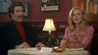 From left to right: Will Ferrell and Christina Applegate sitting together at a table.