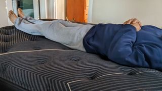 A person lying on the Beautyrest Black K-Class Plush Pillow Top mattress