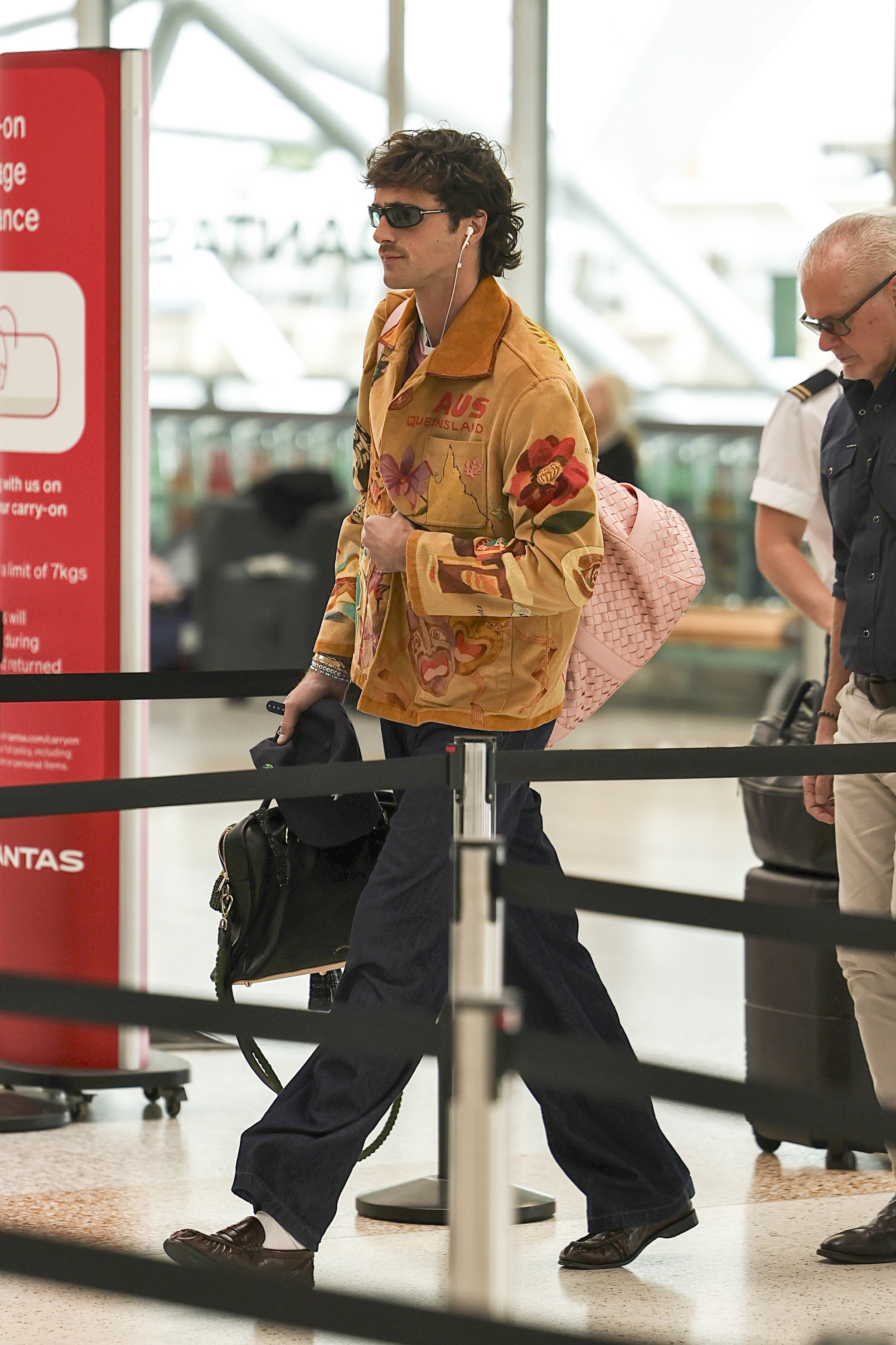 An image of Jacob Elordi at the airport in Brisbane, wearing a Bode jacket and Bottega Veneta bag.