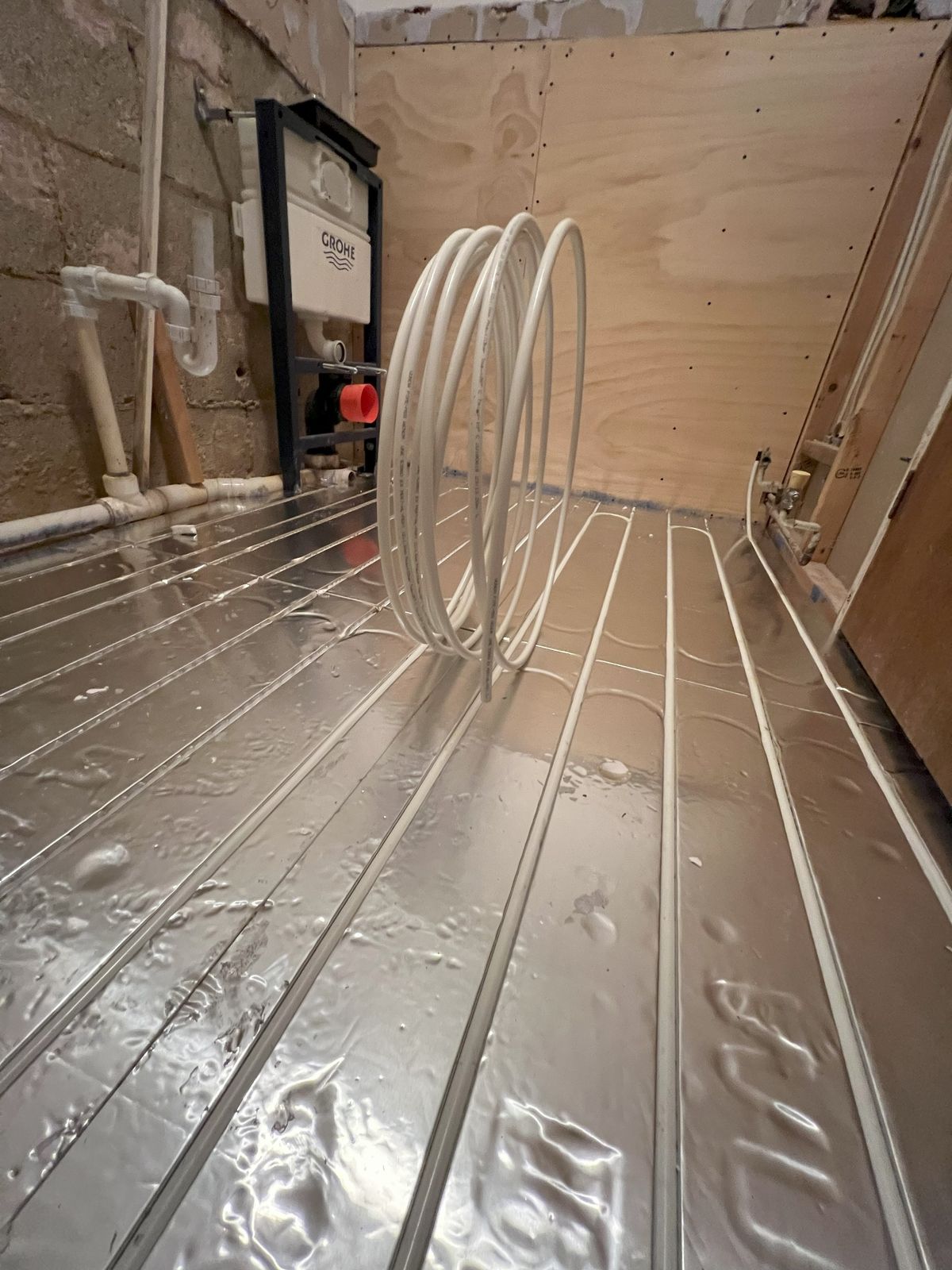 Silver pipe matts with underfloor heating pipes slotted into it