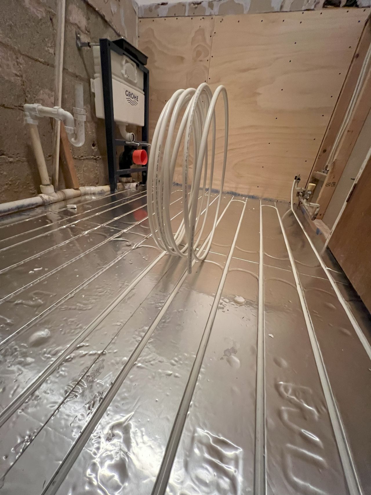 Silver pipe matts with underfloor heating pipes slotted into it