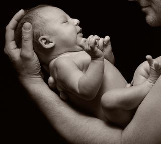 A man holds a baby in his arms.
