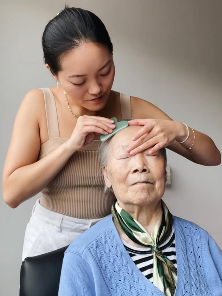 Stephanie Zheng practicing gua sha with her grandmother