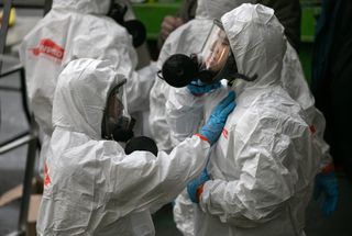 workers put on personal protective equipment before entering the LifeCare facility in Kirkland Washington, where a huge outbreak of COVID-19 occurred.