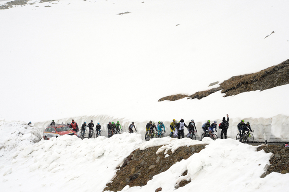 The peloton cuts through the snow bank