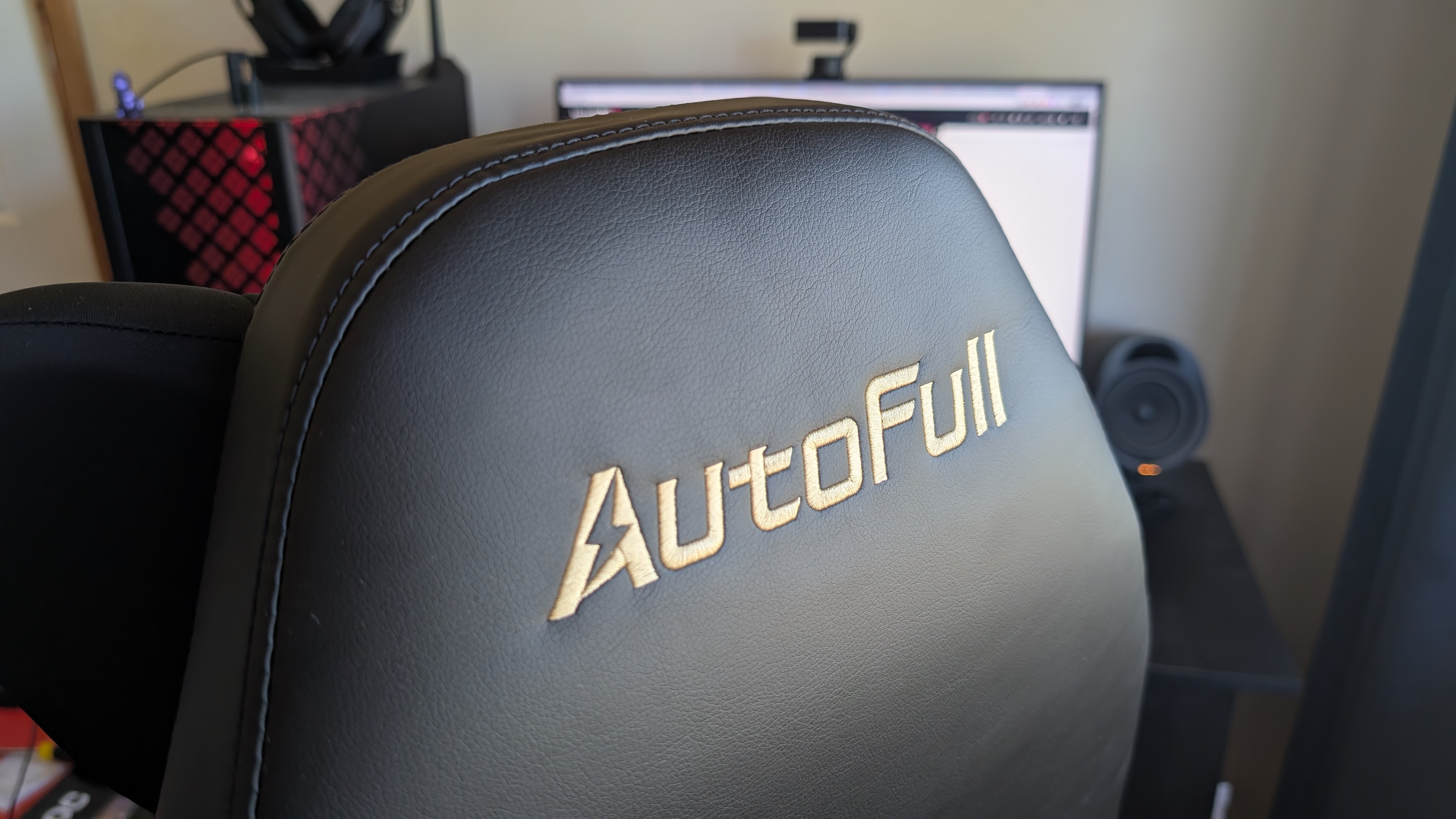 The AutoFull M6 Ultra gaming chair pictured in front of a desk with a gaming PC setup.