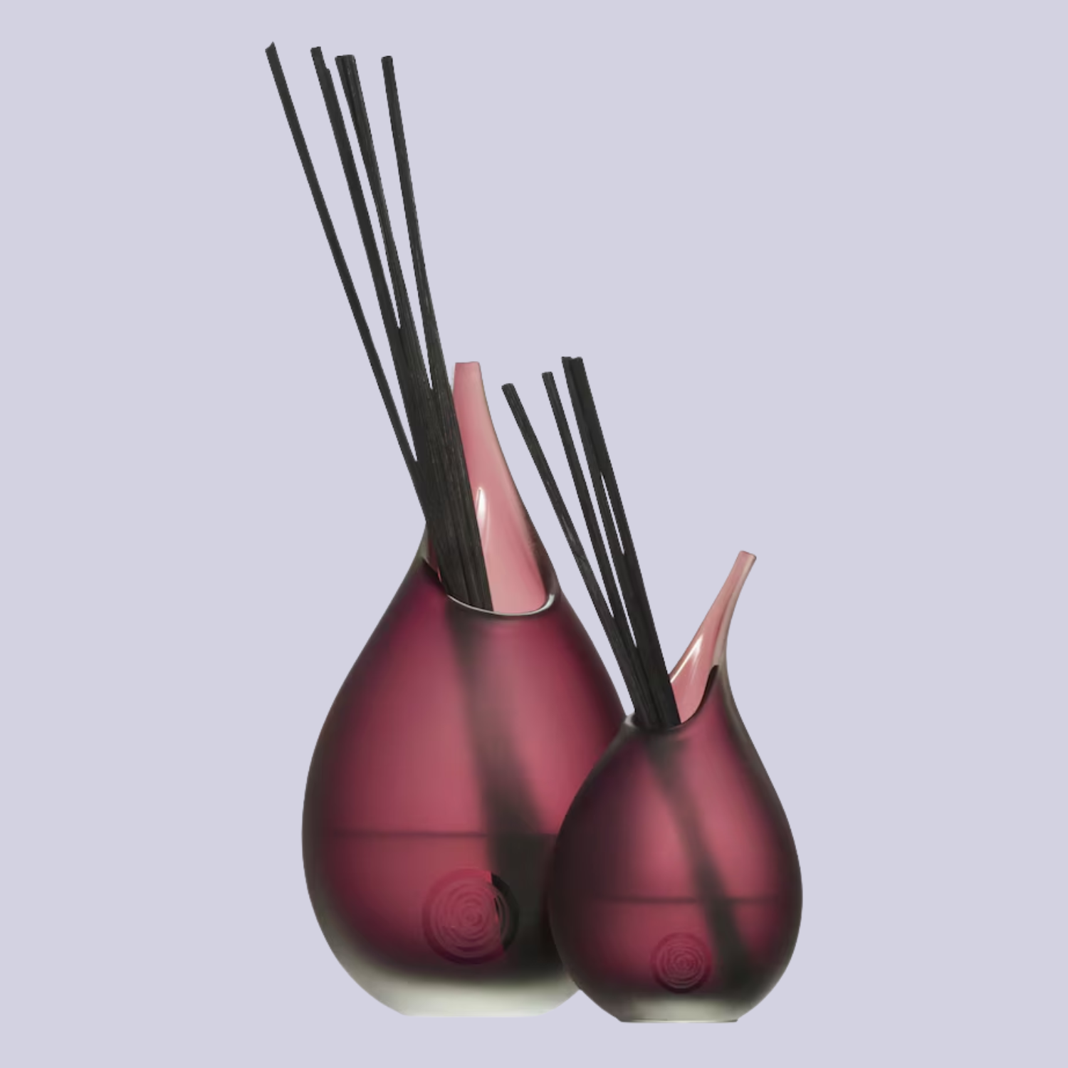 A pair of dark purple glass reed diffusers