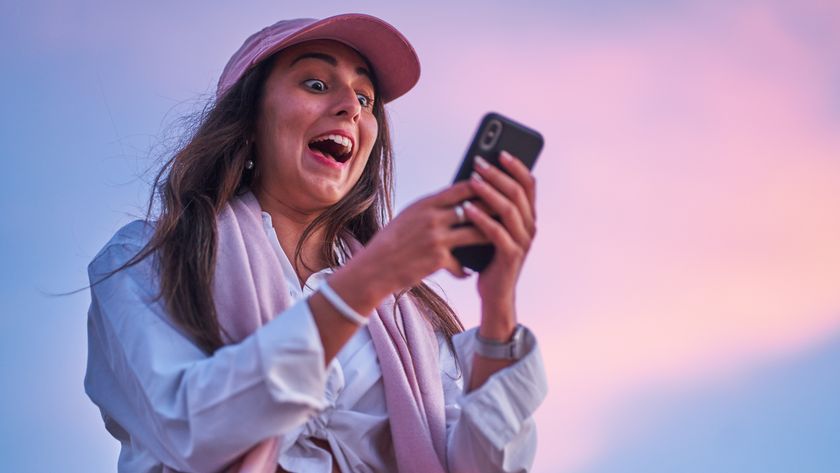 From below amazed Hispanic female with dark long hair reading surprising news on cellphone against cloudy sundown sky in Mallorca, Spain
