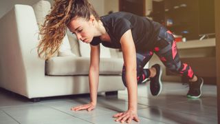 Woman performing mountain climber exercise at home