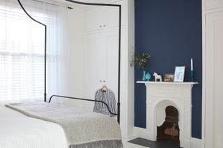 White and blue bedroom with four-poster bed in Victorian terrace on Isle of wight