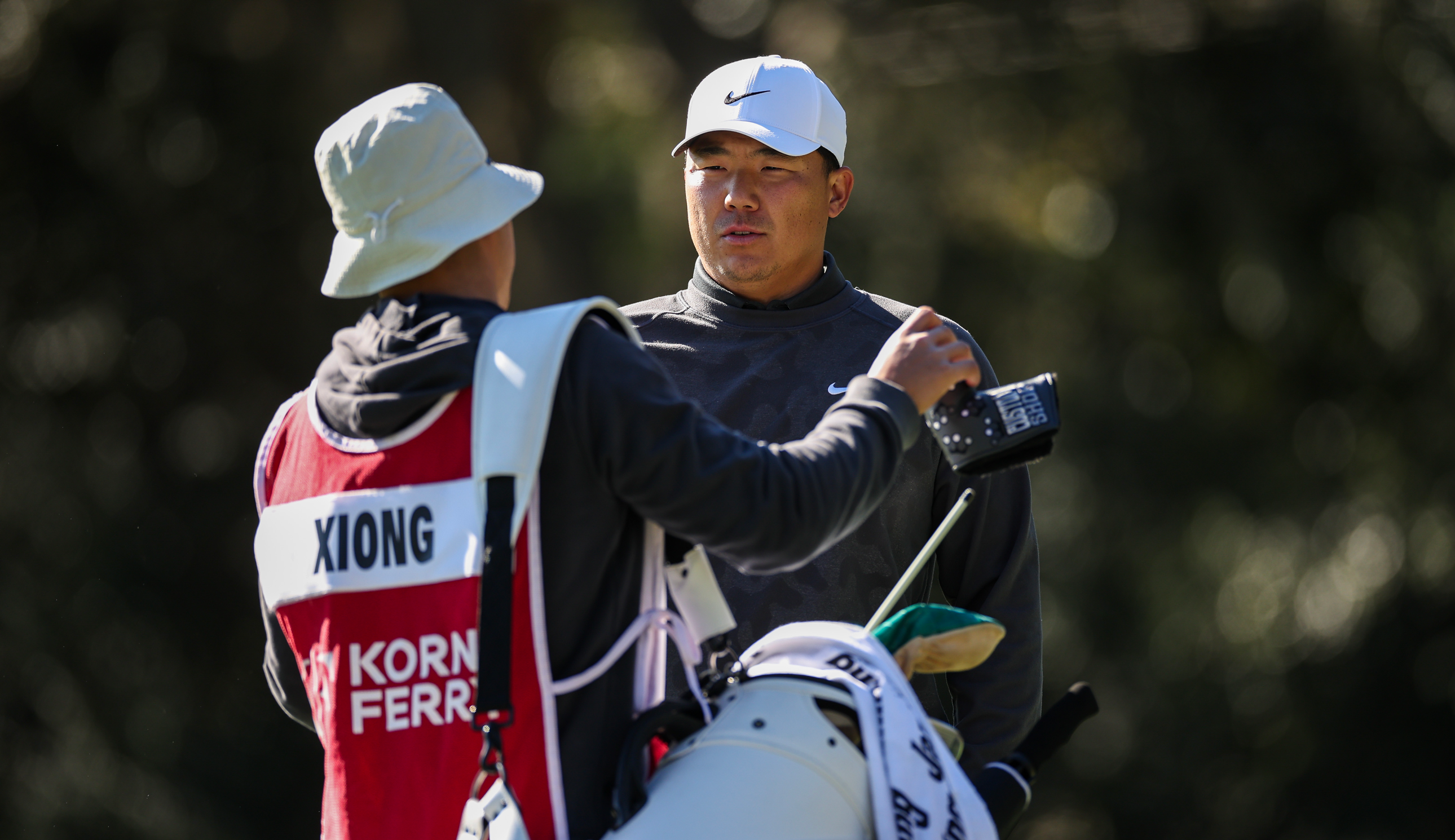 Norman Xiong speaks to his caddie during PGA Tour Q-School