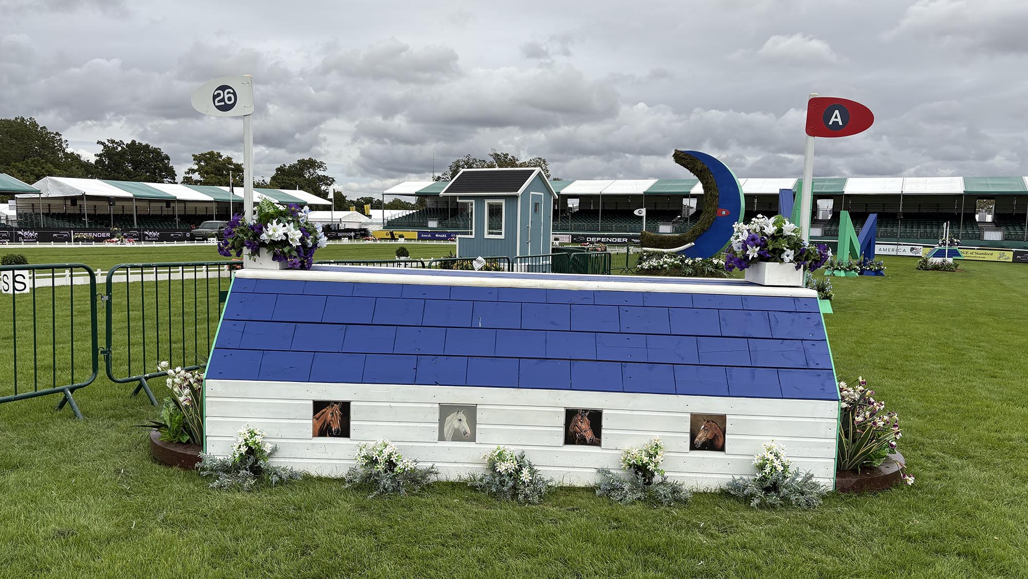 Blue and white house fence on the Burghley cross-country course 2026