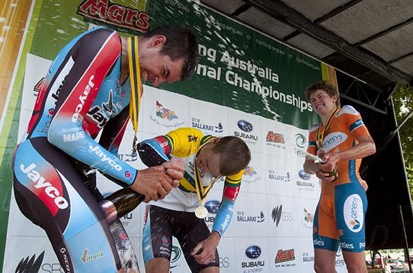 Damien Howson wrestles with the champagne as race winner Rohan Dennis lends a hand and Campbell Flakemore (far right) takes an opportunity.