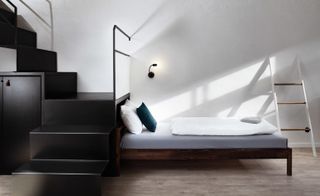 Bed in front of staircase