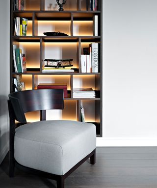 wooden shelf with back-lit shelving, gray and black wooden lounge chair