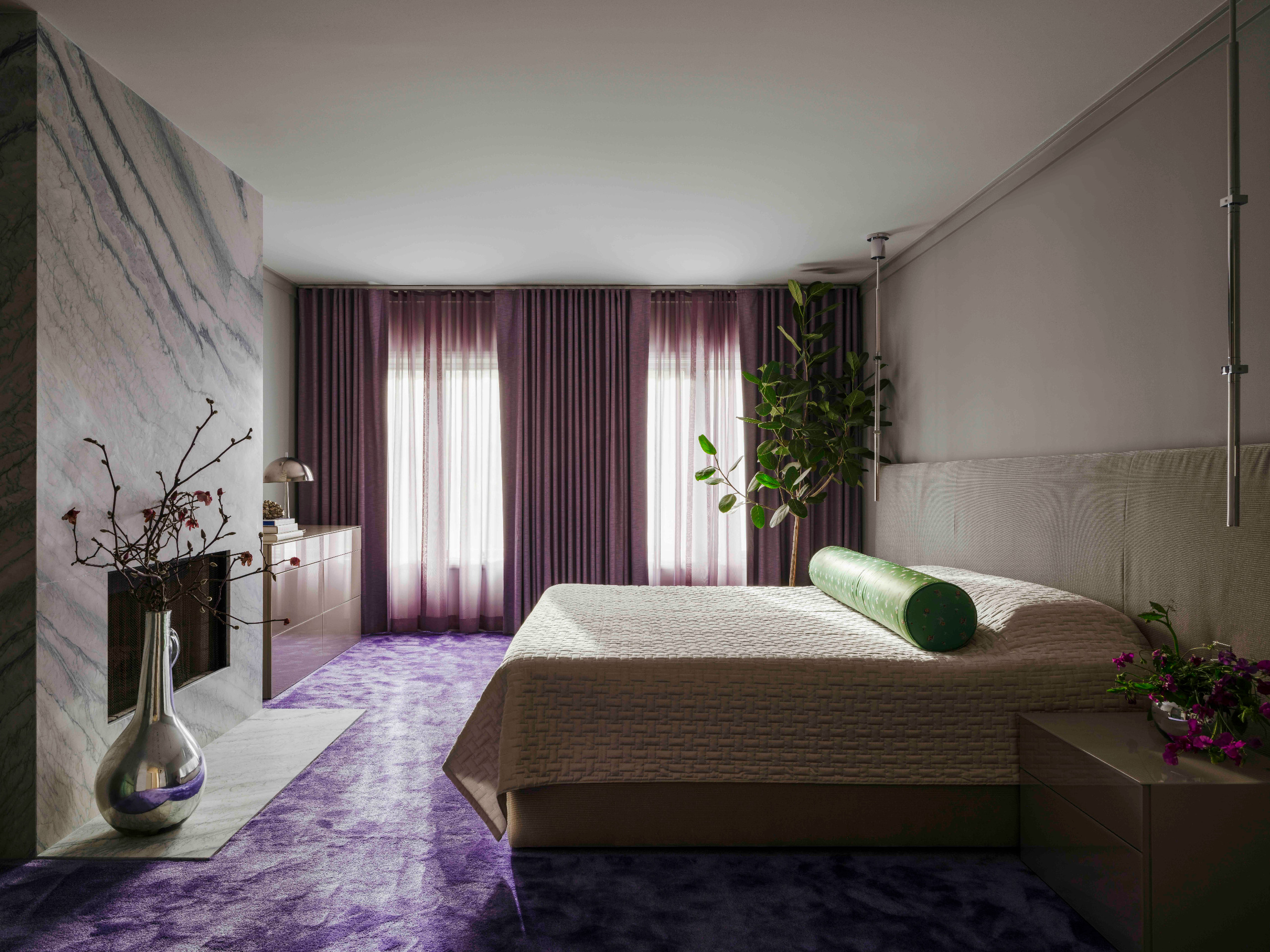 A contemporary bedroom with purple floors, velvet headboard and stainless steel accessories