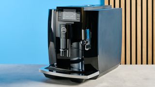 the jura E8 automatic coffee machine in piano black with a 64 ounce water tank, screen, and jura logo on the front