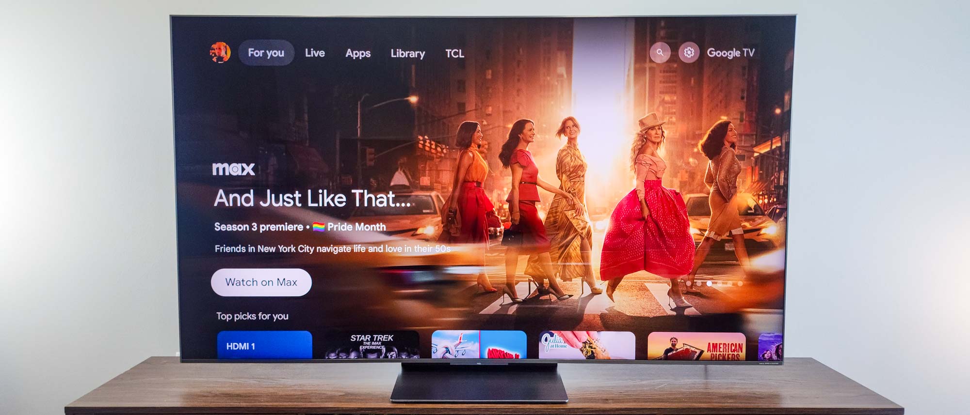 A TCL QM8K QD-Mini LED TV on a TV stand.