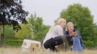 Joanna helps release a bird under the watchful eye of a handler.