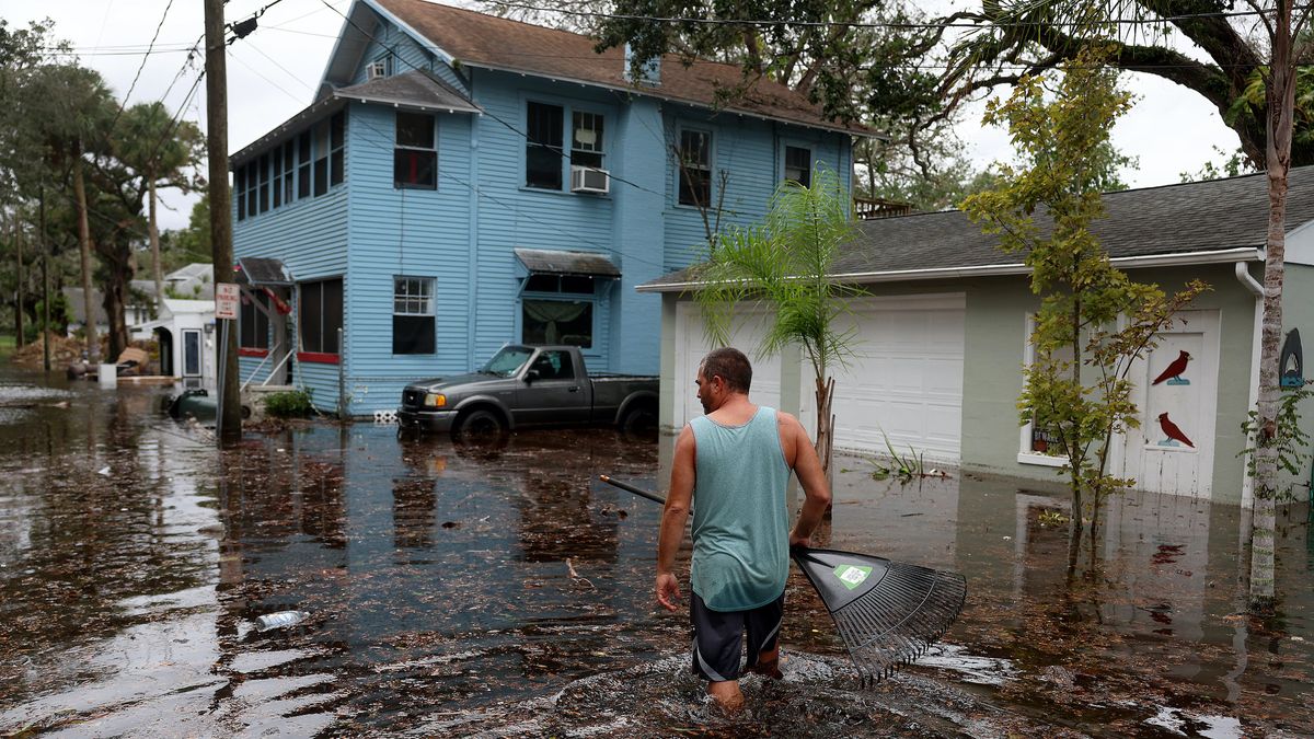 Jason Elam wades through flood waters around his home after Hurricane Nicole blew ashore on Nov. 10, 2022 in Daytona Beach, Florida.