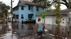 Jason Elam wades through flood waters around his home after Hurricane Nicole blew ashore on Nov. 10, 2022 in Daytona Beach, Florida.