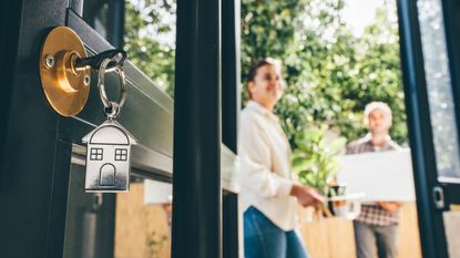 A key and key chain dangle from the lock of a home as home buyers move in.