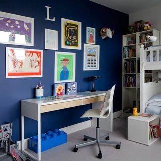 kids bedroom with photoframes on blue wall