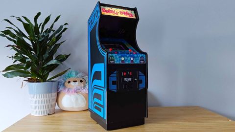 Quarter Arcades Taito Bubble Bobble arcade machine with marquee illuminated sitting on woodgrain surface 