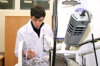 A scientists works with a meteorite from the Chelyabinsk fireball event at the Ural Federal Agency