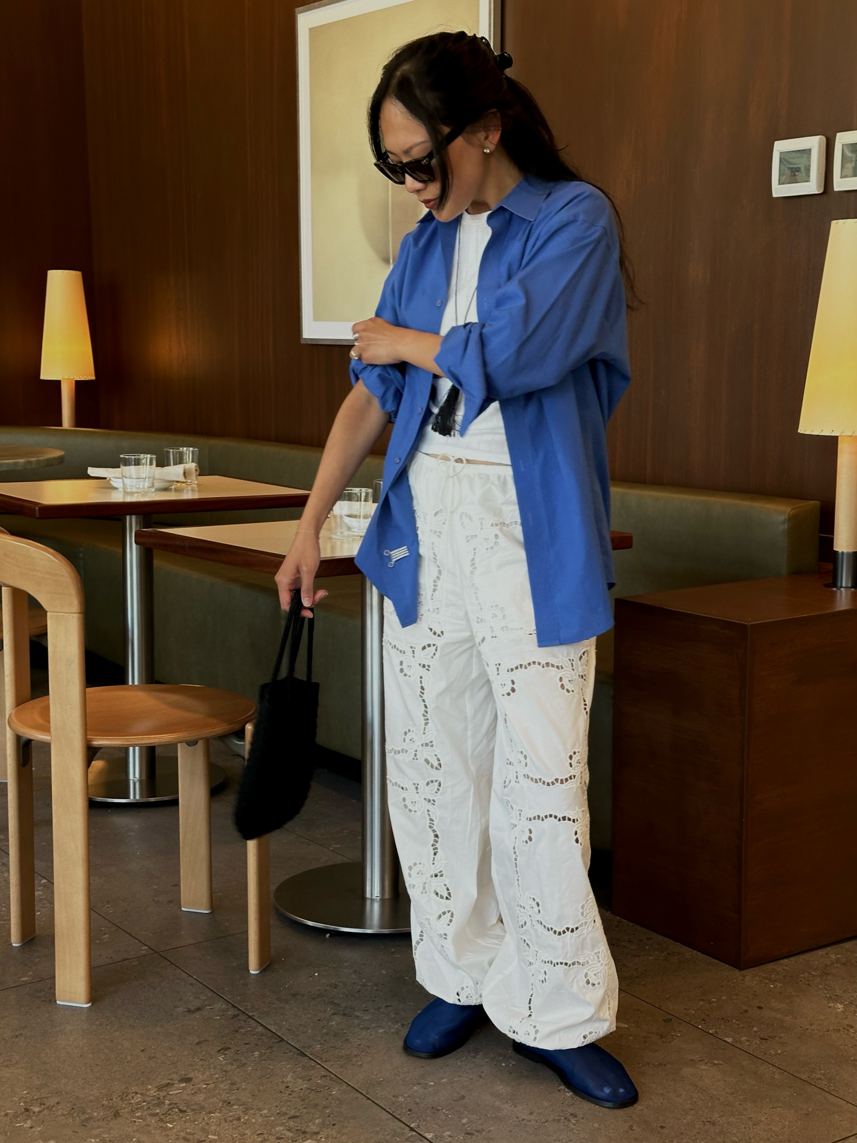 An image of @dawn.tan wearing a cobalt blue shirt with broderie anglaise trousers and cobalt blue mesh flats.