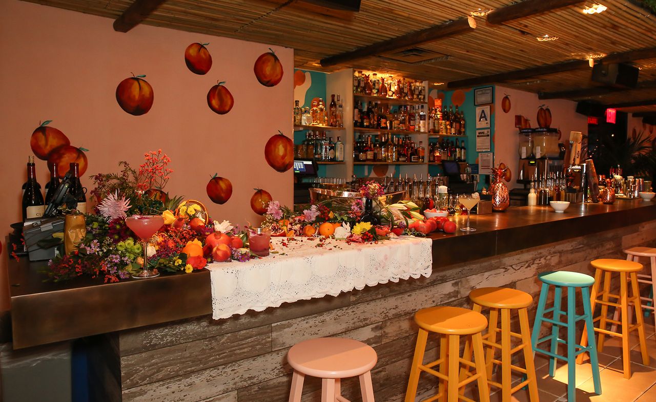 Bar with colourful stools, wall art &amp; exotic fruits