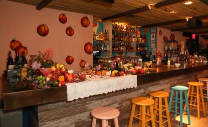 Bar with colourful stools, wall art & exotic fruits