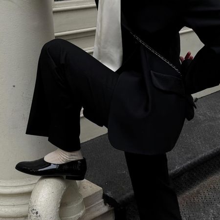 Christie Tyler wearing a suit, a silk top, socks, and patent leather Chanel moccasins.