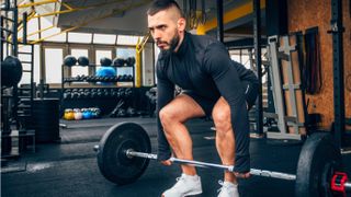 Man performing barbell deadlift in the gym during workout in set-up position