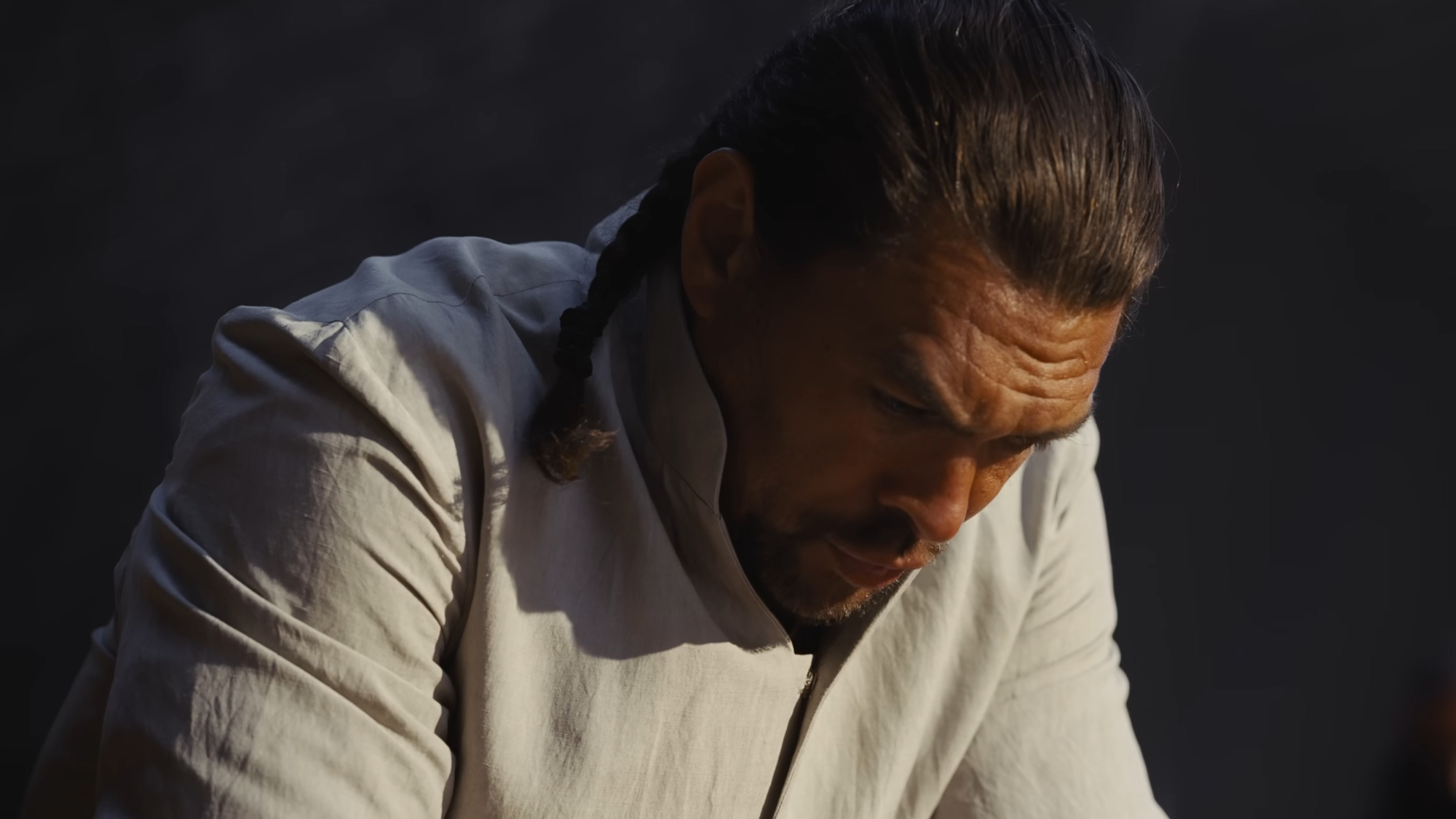a man in a white uniform bows his head
