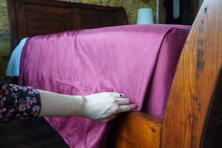 Folding the side of the bed to create a hospital corner