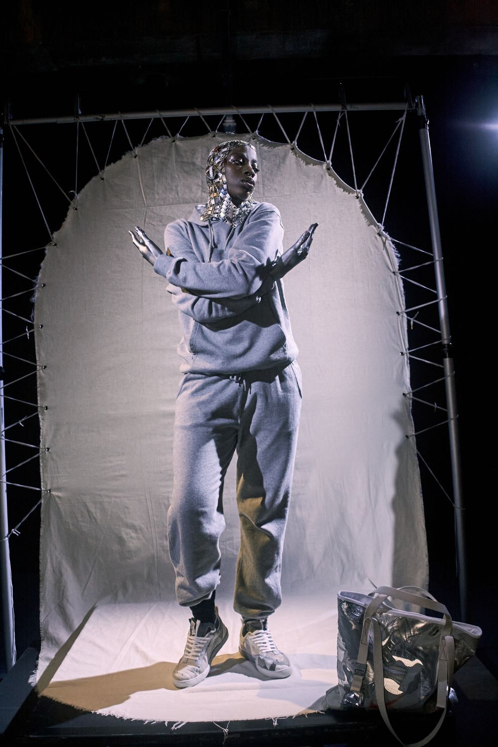woman wearing silver head cover and grey tracksuit with recycled and reworked bag