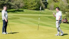 golfer fist pumps after holing a putt on a green