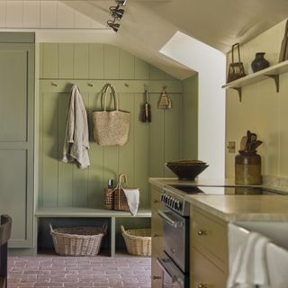 entrance area with green panelled walls and coat pegs, built-in bench and storage baskets