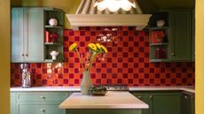 bright kitchen with bold red and burgundy checkered tile backsplash, forest green kitchen cabinets, and a chartreuse wall