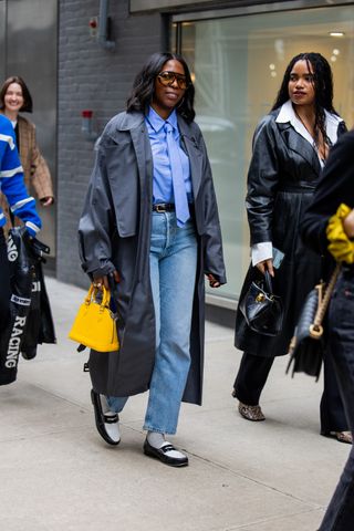 A woman walks at New York Fashion Week in a tie and jeans