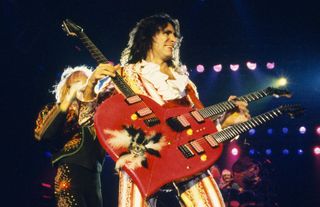 Steve Vai plays his distinctive three-neck-heart-shaped-guitar on stage with David Lee Roth at Budokan, Tokyo, Japan, 3rd October 1988.