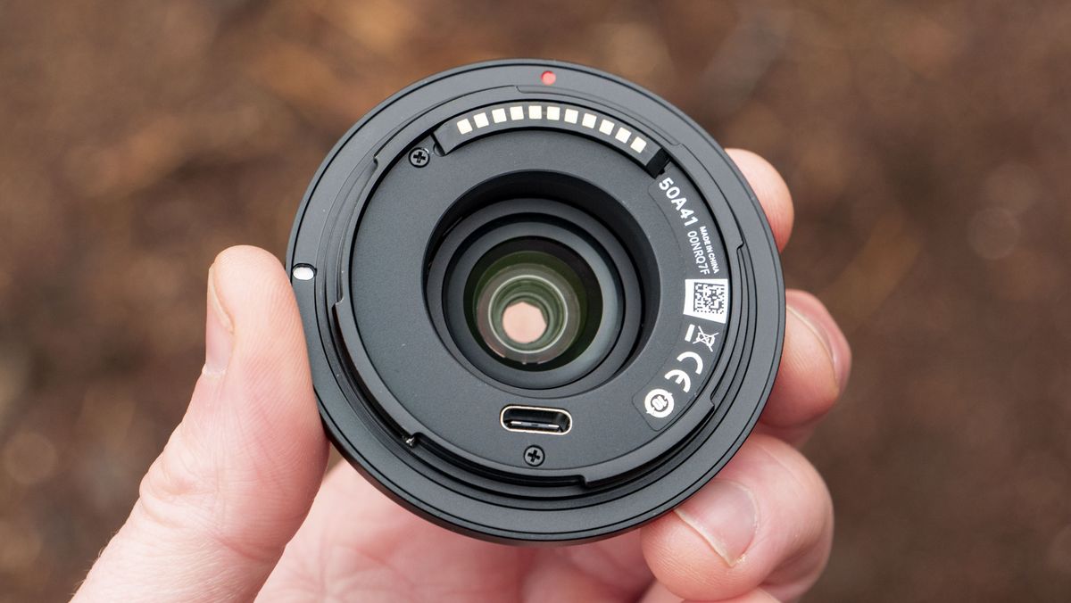 Viltrox AF 28mm f/4.5 body cap lens in photographer's hand
