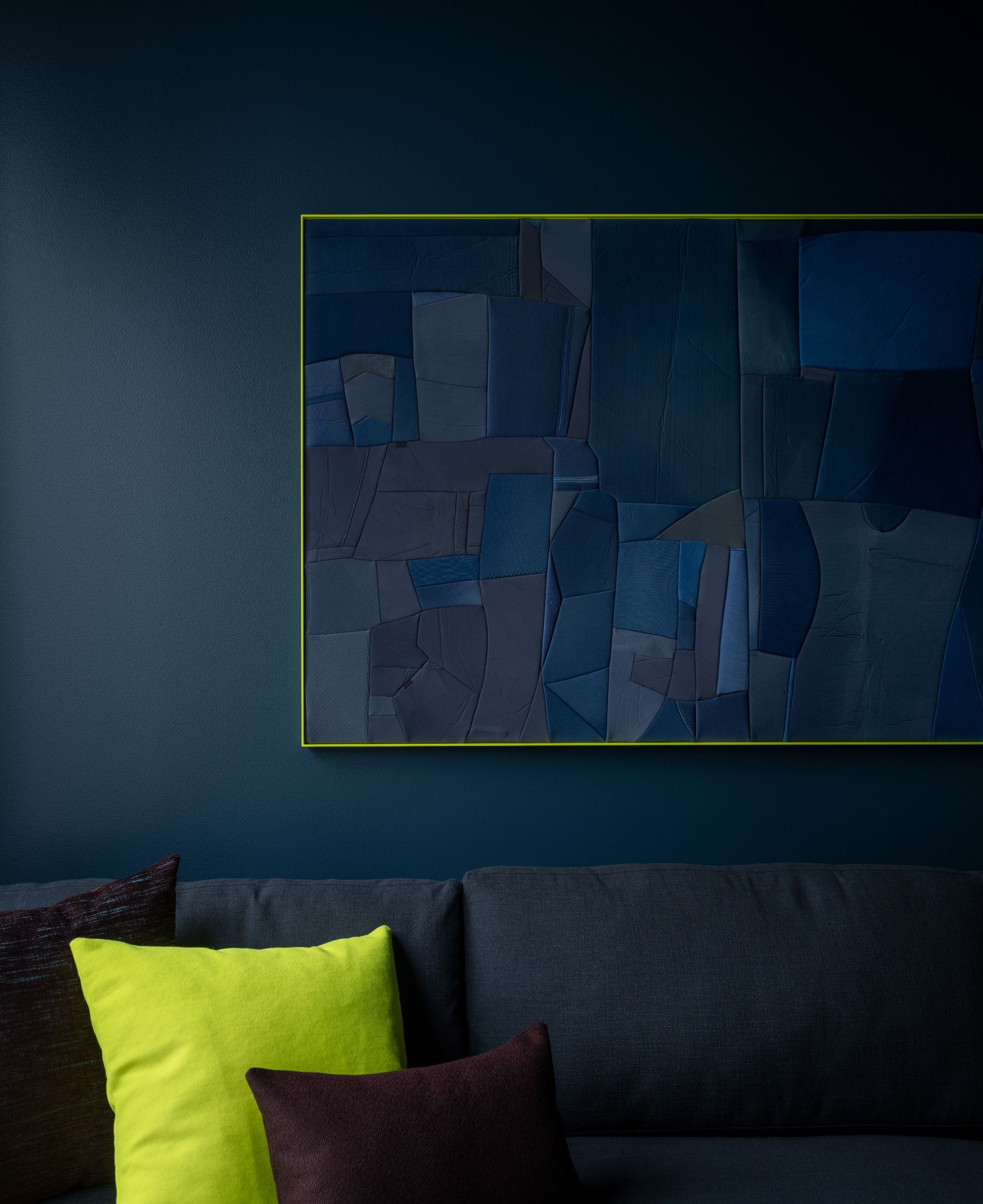 a blue room with a neon yellow framed artwork